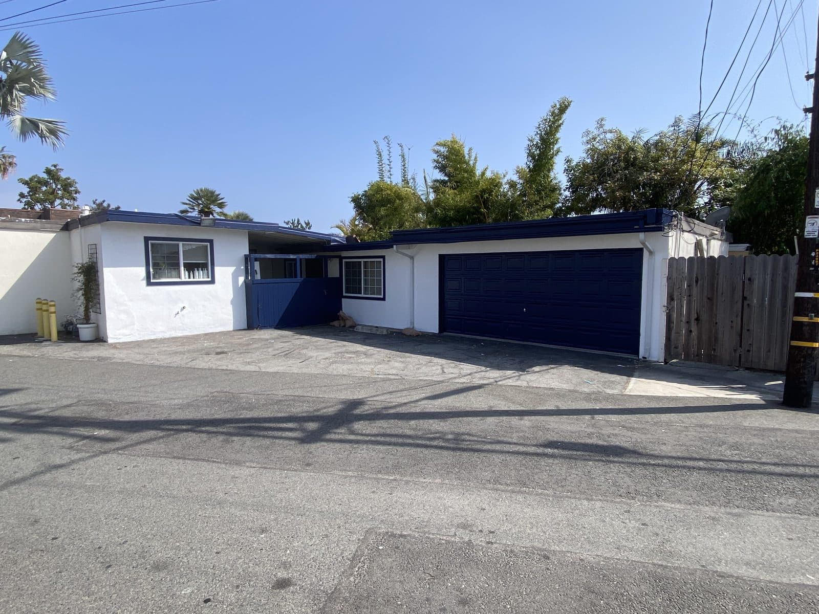 Home exterior repainted, white walls with dark garage doors